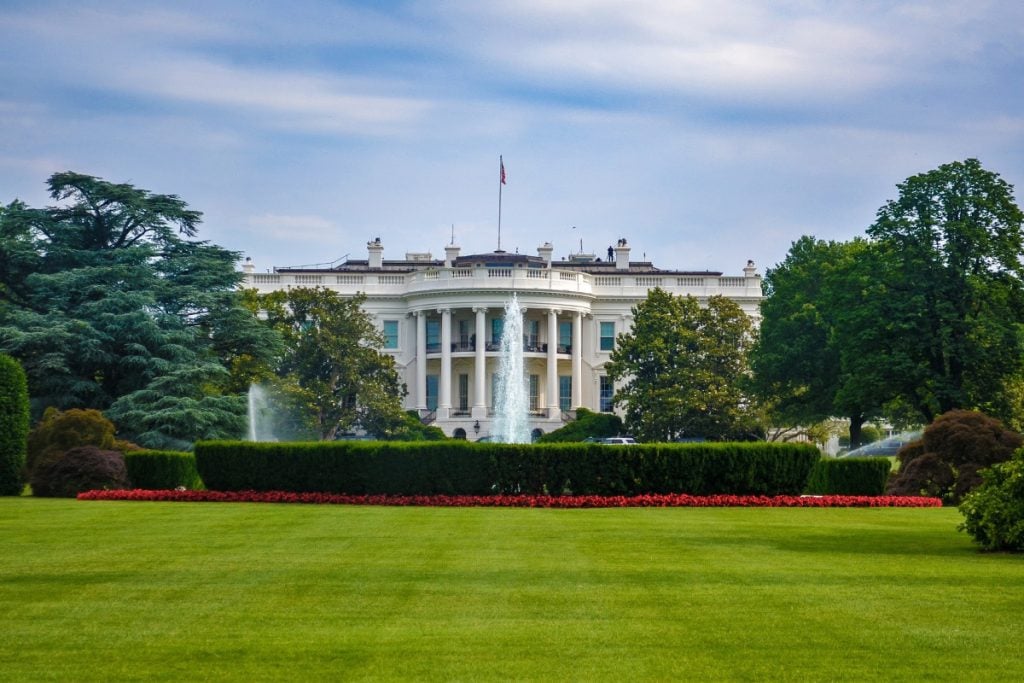 Photo of the outside of the White House on a sunny day.