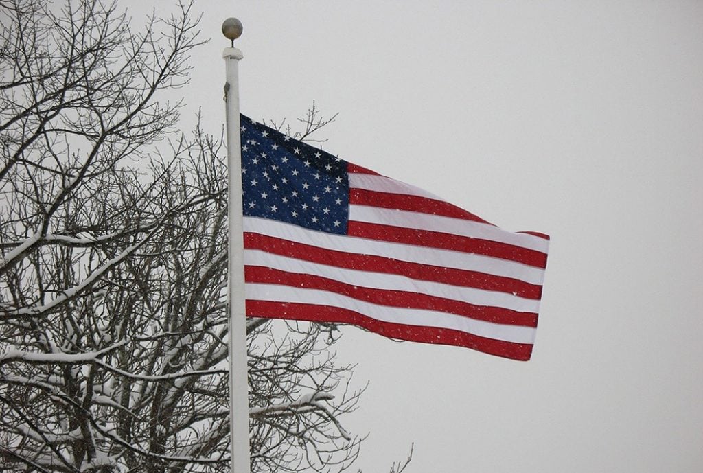 Photo of the American flag on a snowy day in February.