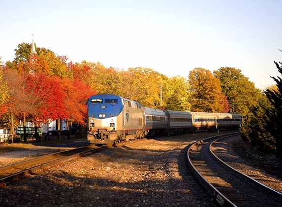 An Amtrak Heartland Flyer train on railroad tracks in fall