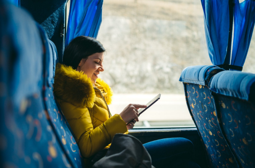 A bus passenger watches a movie on her tablet