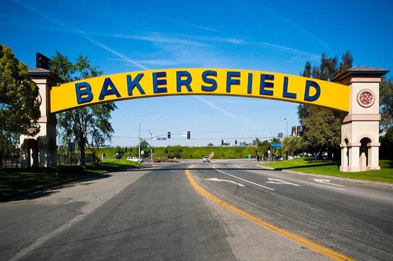 The neon Bakersfield arch sign spanning the road on a sunny day