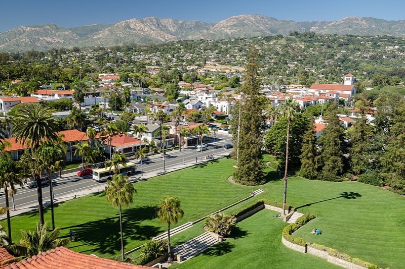 Red tile roofs and palm trees of Santa Barbara seen from the courthouse tower, with the Santa Ynez Mountains behind